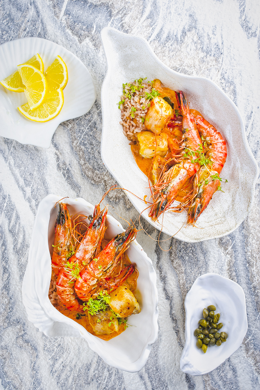Traditional cajun stew red curry with king prawns, fish and red